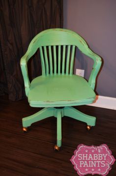 a green chair sitting on top of a hard wood floor next to a sign that says shabby paints