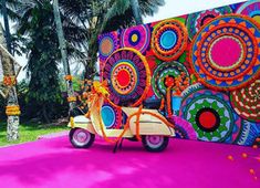 a scooter parked in front of a colorful wall with circles and flowers on it