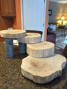 three wooden stools stacked on top of each other in front of a living room door