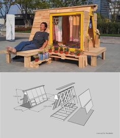 a man sitting on top of a wooden bench next to a building with windows and doors