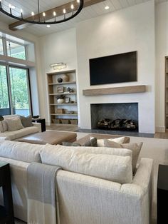 a living room filled with furniture and a flat screen tv mounted on the wall above a fireplace