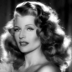 a black and white photo of a woman with long hair wearing an evening dress in the 1950's