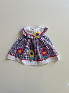 Sweet summer sundress! Tagged 12 months, seems accurate. Measures 14 inches long. Excellent condition. Retro Spring Playtime Dresses, Beach Floral Sundress For Babies, Beach Sundress With Floral Print For Babies, Vintage Summer Dresses For Playtime, Summer Vintage Dresses For Playtime, Vintage Dresses For Summer Playtime, Cute Lined Cotton Sundress, Sunflower Applique, American Doll Clothes