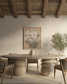 a dining room table with chairs and a vase on the table in front of it