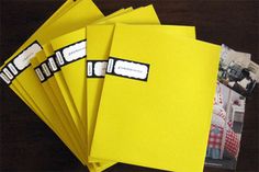 five yellow folders with stickers on them