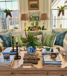 a living room filled with furniture and lots of plants on top of a coffee table