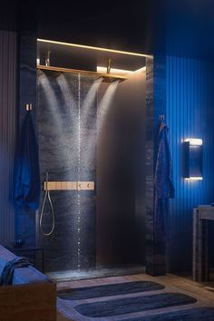 a bathroom with a shower head and blue lighting in the shower area, next to a bed