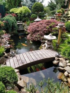 a wooden bridge over a small pond in a garden