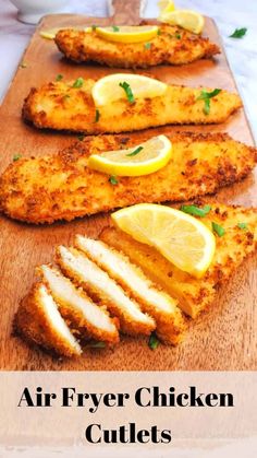 air fryer chicken cutlets on a cutting board with lemons and parsley