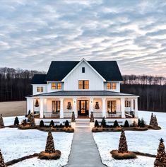 a white house with christmas trees in the front yard