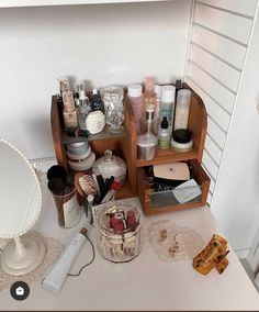 an assortment of personal care items on a vanity counter in a room with white walls