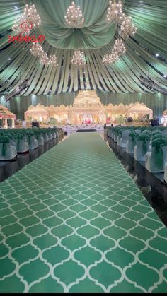 the inside of a tent with rows of chairs and chandeliers on each side