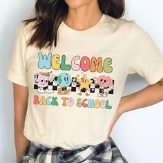 Introducing our stylish and nostalgic Back to School Teacher Shirt starring a host of Y2K Characters and that old-school checker print! This unique and eye-catching shirt is designed specifically for teachers who want to showcase their excitement for being back to school and their love for the trendy return of the Y2K era.  Not only is this shirt a fashionable choice, but it also serves as a great conversation starter with your students and colleagues. The Y2K characters displayed on the shirt w Retro Crew Neck T-shirt For School, Retro Crew Neck T-shirt For Back To School, Retro Letter Print T-shirt For School, Retro Short Sleeve T-shirt For Back To School, White Retro T-shirt For School, Retro White T-shirt For School, School T-shirt With Graphic Design, Crew Neck, White Retro T-shirt For Back To School, Retro Multicolor T-shirt For School