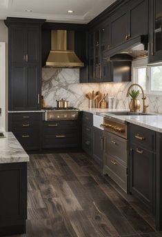 A blend of modern and traditional styles, this kitchen features two-tone cabinets with dark lower cabinets and light upper cabinets. The central island in a contrasting color provides extra workspace, while a marble backsplash and brass fixtures add elegance to the design. Moody Kitchen Remodel, Dark Charcoal Cabinets, White Top Cabinets Dark Lower, Dark Taupe Kitchen Cabinets, 2 Color Kitchen Cabinets, Moody Modern Kitchen, Dark Lower Cabinets, Taupe Kitchen Cabinets, Taupe Kitchen