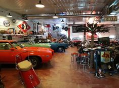 a garage filled with lots of different colored cars and drums on the floor next to each other