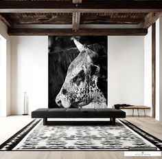 a black and white photo of a cow in a living room with wood beams on the ceiling