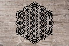 the flower of life symbol is shown on a wooden surface, and it appears to be made out of wood planks