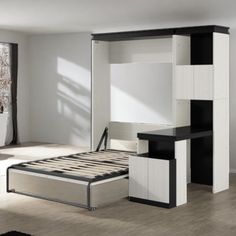 a white and black bedroom with a bed, desk and mirror in it's corner