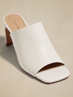 Look closely: these statement-making slides have a distinctive heel shape—at once stiletto-like when viewed from the side, but wide enough to offer the comfort and stability of a wider, block heel.  We cut these from beautiful, Italian leather and added an extra layer of foam to the lining for added comfort.  Italian leather uppers and lining.  Rubber soles.  Made in Portugal.  B width.  Heel height: 3" Chic Slip-on Block Heels For Formal Occasions, Chic Slip-on Block Heels With Padded Heel, Sleek Slip-on Heels With Sculpted Heel, Modern Block Heels With Padded Heel And Almond Toe, Modern Block Heels With Almond Toe And Padded Heel, White Square Toe Heels With 4-inch Heel, Modern Almond Toe Block Heels With Padded Heel, Classic High Heel Mules With Contrasting Heel Counter, Classic High Heel Mules With Sculpted Heel