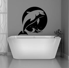 a bathtub with a dolphin wall sticker on it