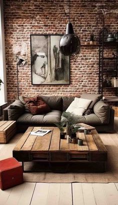 a living room with brick walls and wooden flooring, large sectional couch in the middle