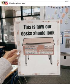 a person holding up a sign that says, this is how our desks should look