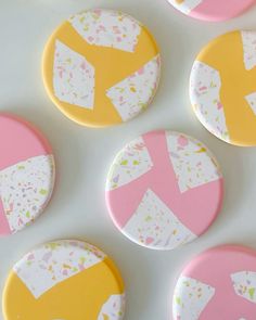 some pink and yellow buttons on a white surface