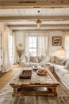 a living room filled with white furniture and lots of windows