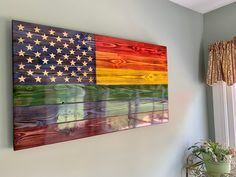 an american flag is hanging on the wall next to a potted plant and window