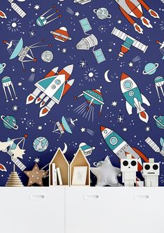 the space themed wallpaper in this children's room is very colorful and fun