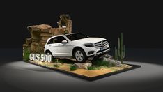 a white car parked in front of a rock formation with cactus and cacti