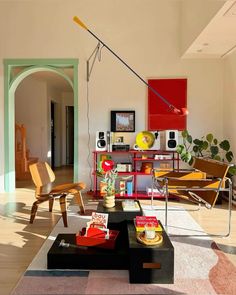 a living room filled with lots of furniture and art on the wall above it's coffee table