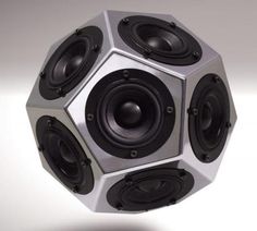 a silver and black speaker sitting on top of a white surface