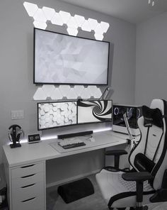 a desk with a computer monitor, keyboard and mouse on it in front of a large screen