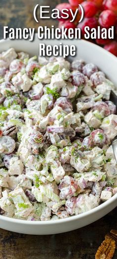 a white bowl filled with chicken salad next to pecans