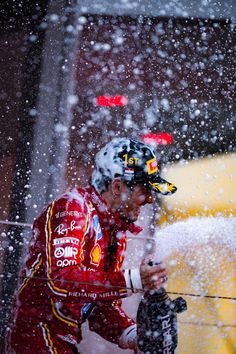 a man in red jacket spraying water on him