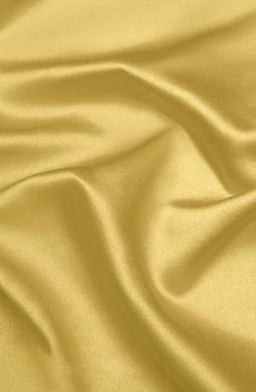 a close up view of a gold colored fabric with very soft folds and wrinkles