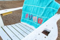 a blue towel sitting on top of a white chair with flip flops on it