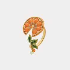 an orange ring with leaves and stones on the front, set against a white background