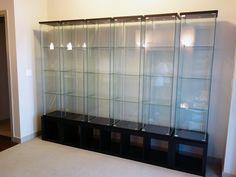 an empty room with several glass shelves on the wall and carpet in front of it