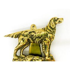 a golden dog brooch with a green base