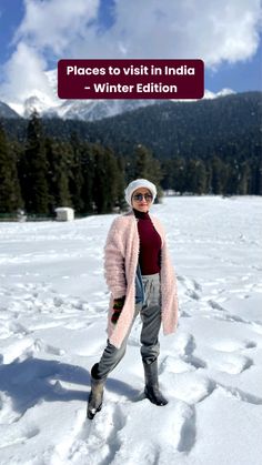 a woman standing in the snow wearing a pink coat