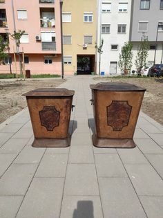 two brown trash cans sitting on top of a sidewalk