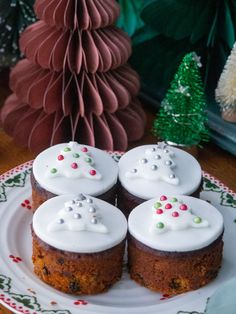 four cupcakes with white frosting on a plate