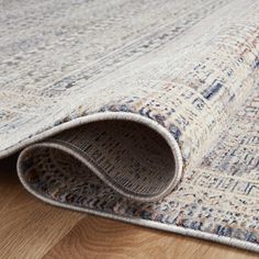 an area rug is laying on top of a wooden floor and it's rolled up