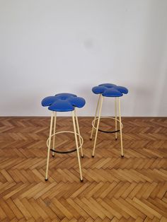 two blue stools sitting on top of a wooden floor