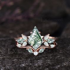 a close up of a ring on a rock with leaves and opalite stones