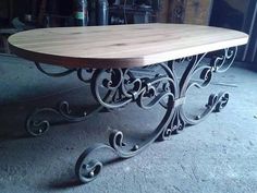 a wooden table sitting on top of a cement floor next to a metal frame wall