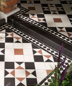 a black and white tiled floor next to flowers