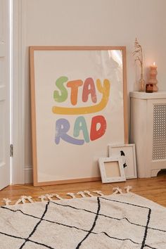 a poster that says stay rad on the wall next to a rug and pictures